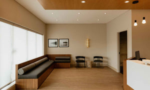 Updated reception area with minimalist, warm-toned interiors, creating an inviting and elegant atmosphere that reflects the dental office's legacy of exceptional care.